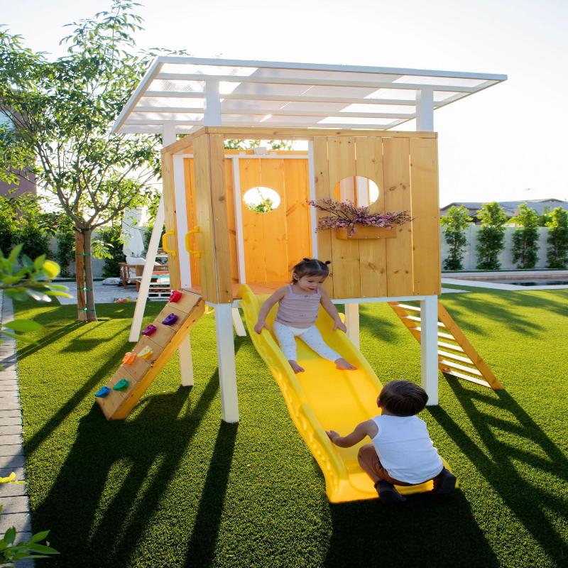 2 Children playing on the Avenlur Forest Playset Slide.